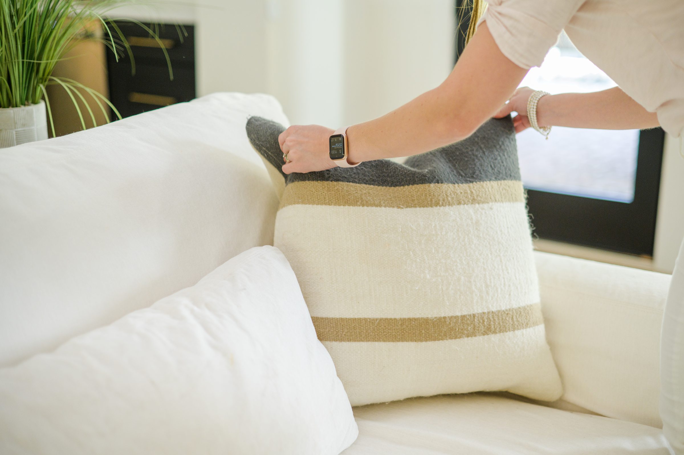 Stacey Caito, Chantilly Realtor, styles a couch during her brand session photographed by Virginia brand photographer, Cait Kramer Photography