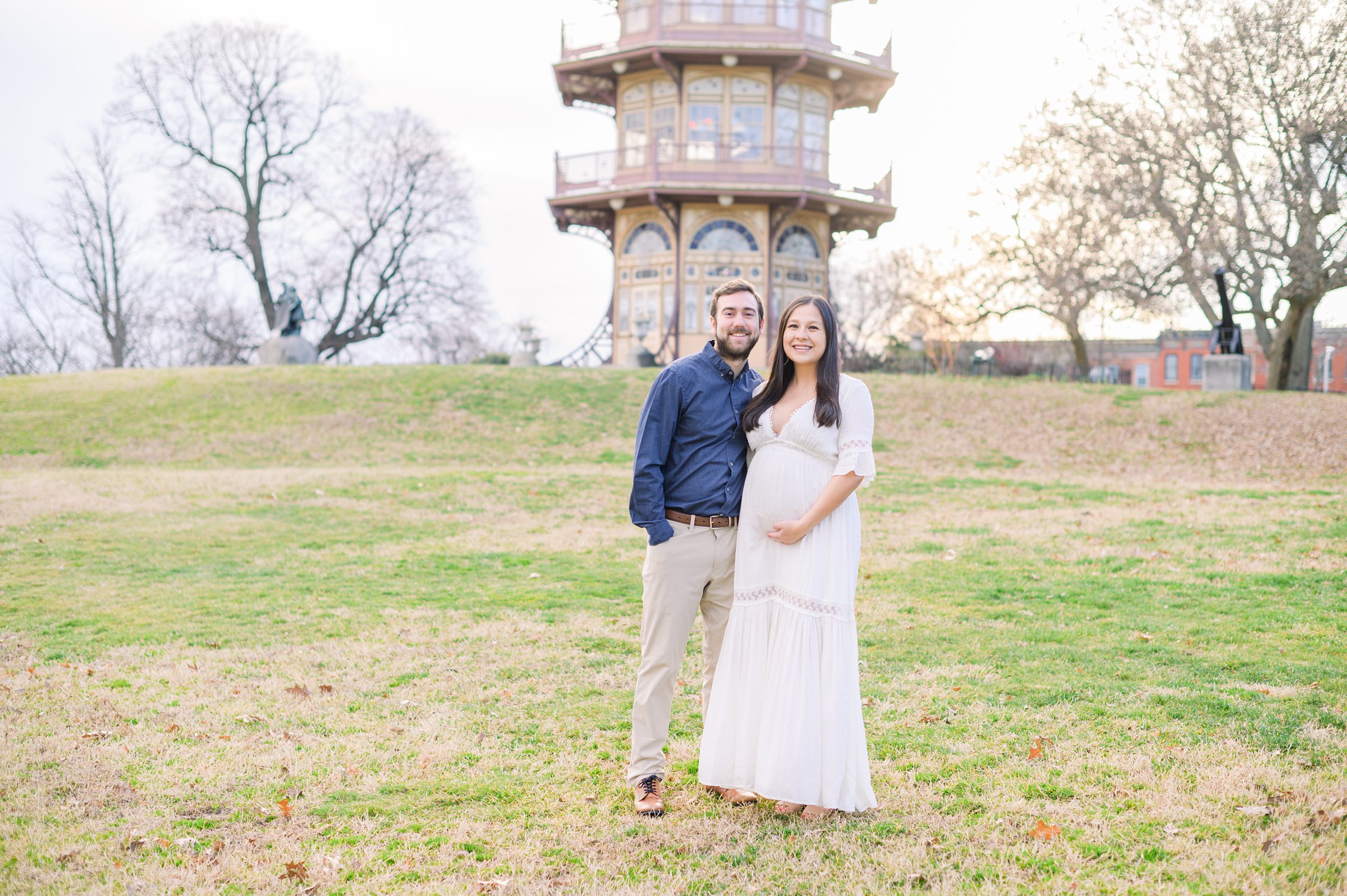 Abby and Nick's maternity photos in Patterson Park in Baltimore County featuring a stunning golden hour and beautiful pink trees.