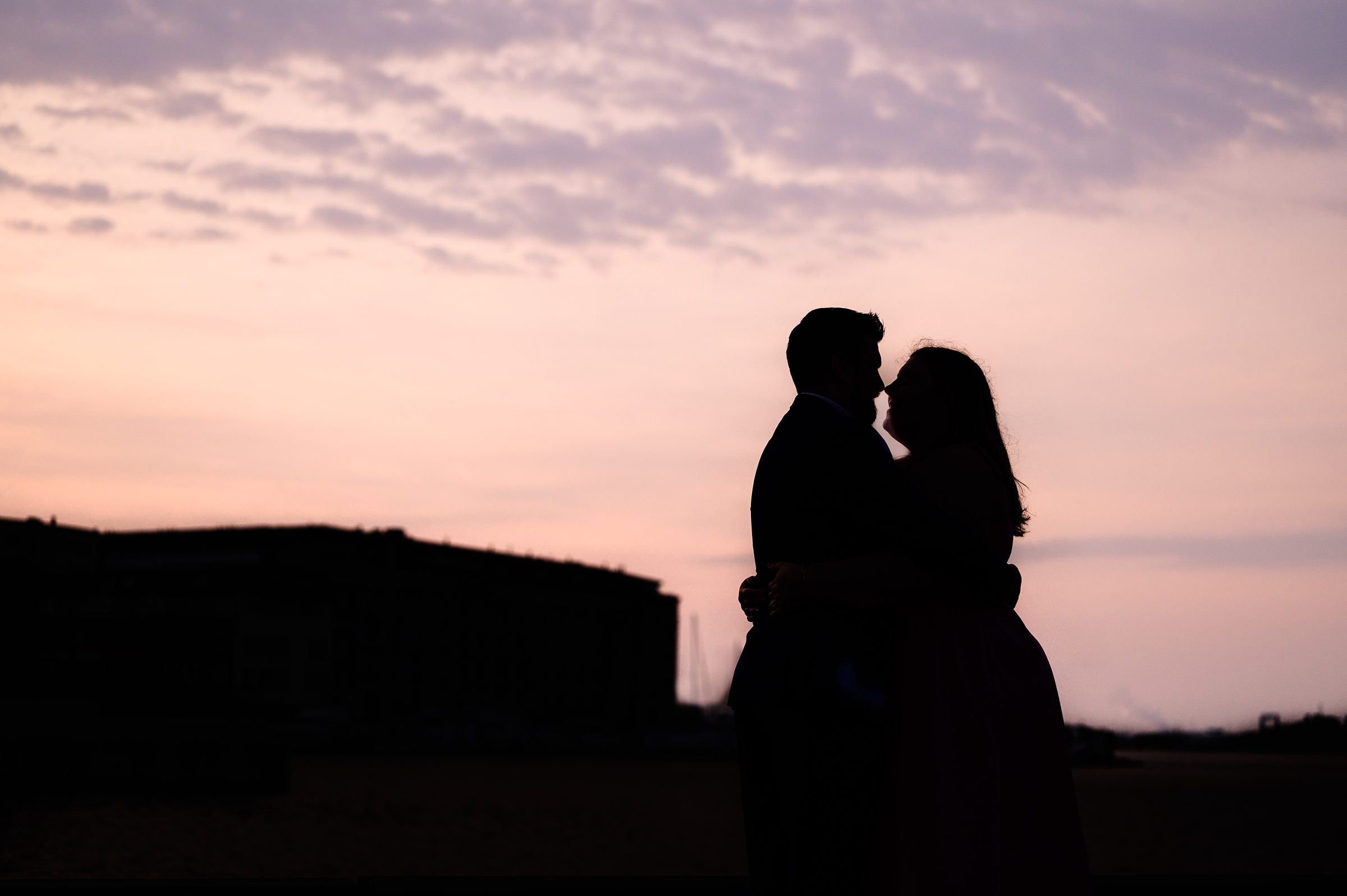 Engaged couple at Fells Point Waterfront for their sunrise engagement session in Baltimore, Maryland photographed by Baltimore Wedding Photographer Cait Kramer Photography.